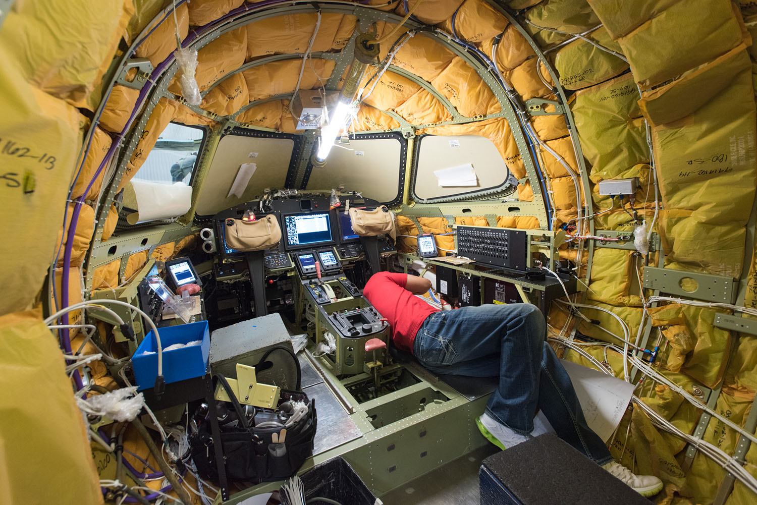 Professional avionics installation technician working on aircraft.